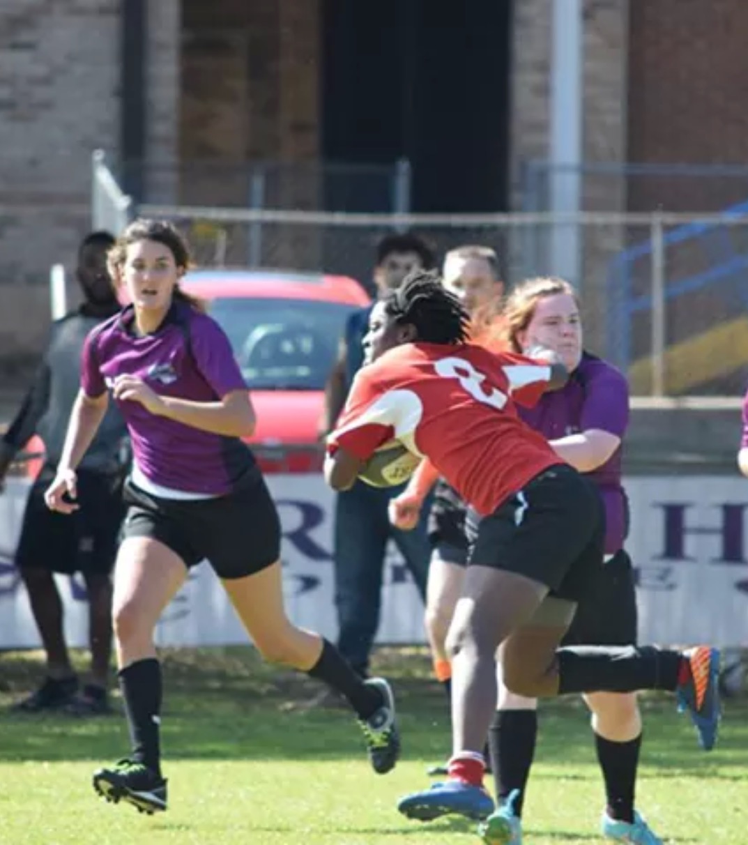 Thompson delivers a stiff arm to a defender. Photo Courtesy of Alabama Rugby. 